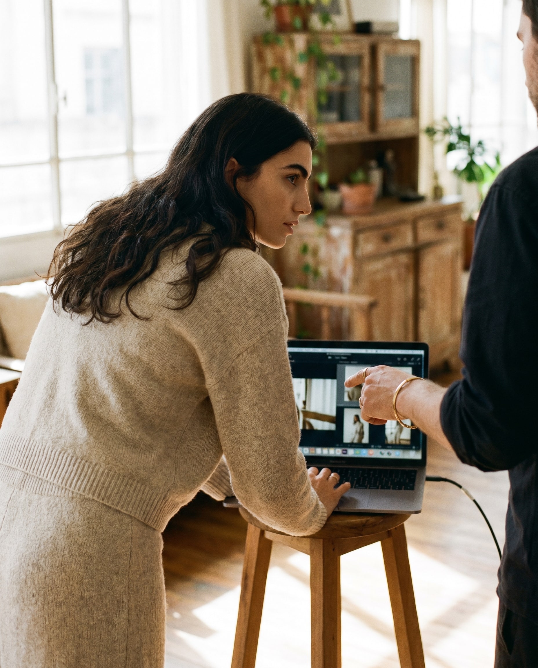 A creator reviewing shots on a monitor with the photographer beside her, editorial daywear, controlled studio light.